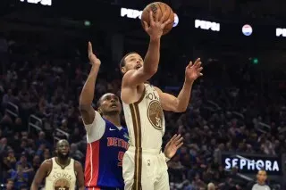 ستيفن كاري، نجم غولدن ستايت، يسجل نقطة في مباراة ضد فريق ديترويت، وسط جمهور متحمس في ملعبه.