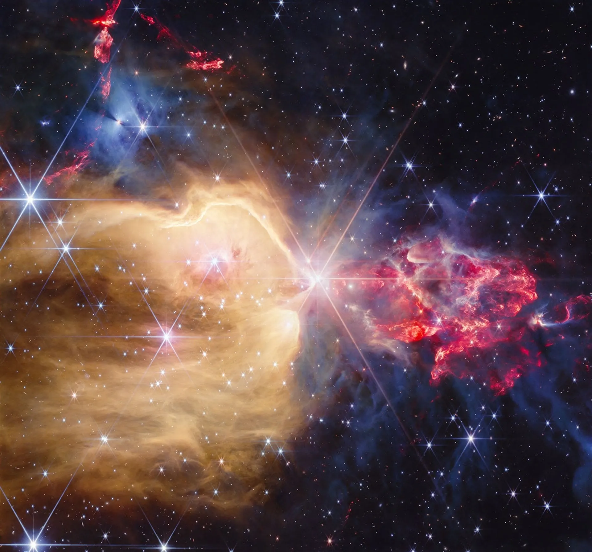 منطقة NGC 7129 النجمية تظهر أكثر من 130 نجماً في مراحل نمو مختلفة وسط غيوم غبارية ملونة، ملتقطة بتلسكوب جيمس ويب تحت الأشعة تحت الحمراء.