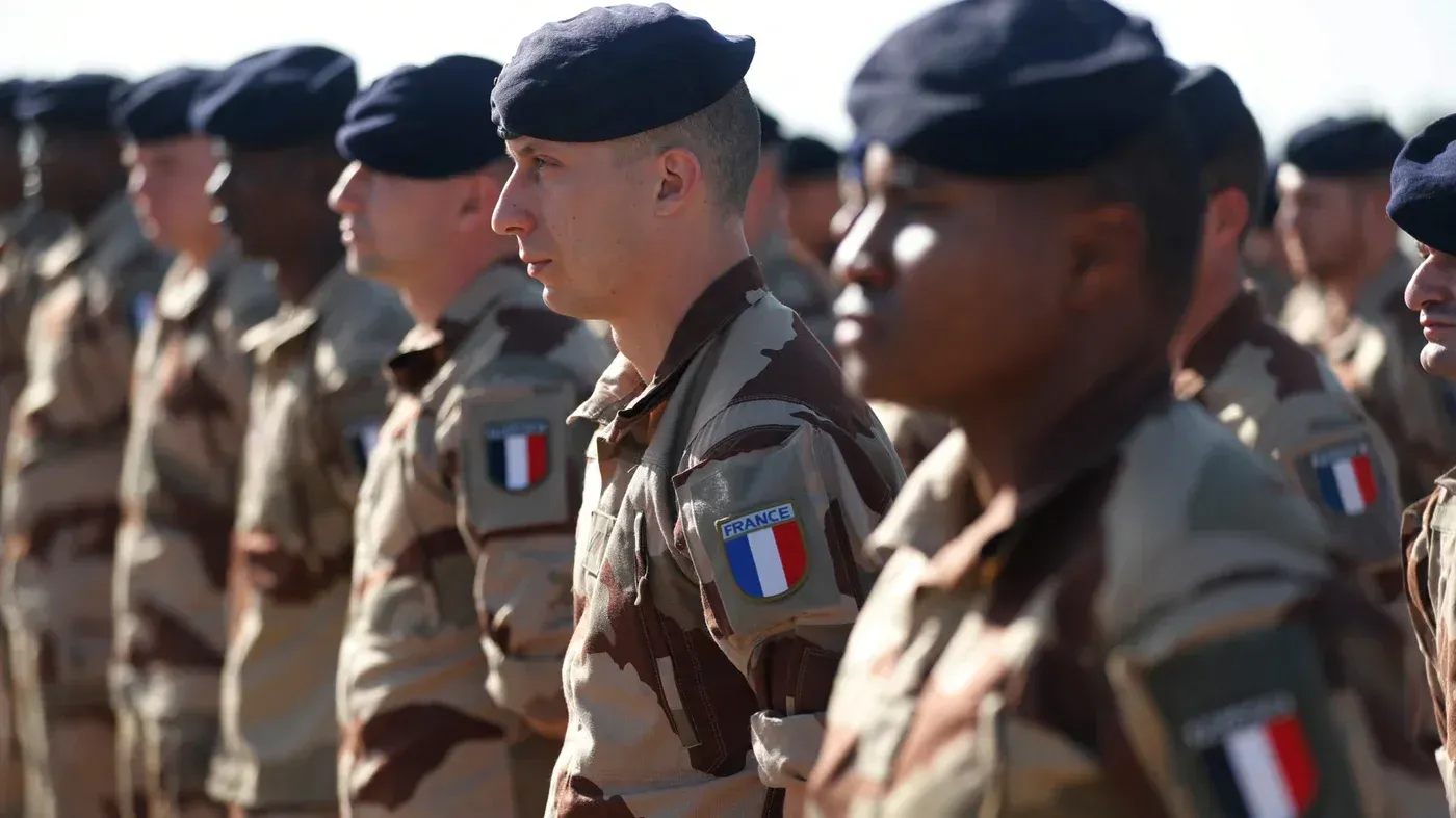 جنود من القوات الفرنسية يرتدون زيهم العسكري في تشكيل، يظهرون في قاعدة عسكرية في العراق وسط تصاعد التوترات الإقليمية.