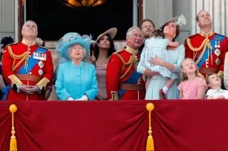 مجموعة من أفراد العائلة المالكة البريطانية، بما في ذلك الملك تشارلز الثالث، يشاهدون حدثًا رسميًا من شرفة قصر باكنغهام.