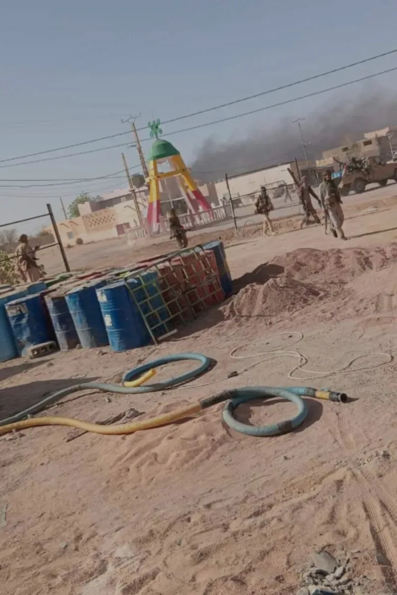 جنود يرتدون زيًا عسكريًا يتواجدون في موقع هجوم في مالي، مع وجود دمى ملونة في الخلفية، مما يعكس الأثر المدمر للصراع على المدنيين.