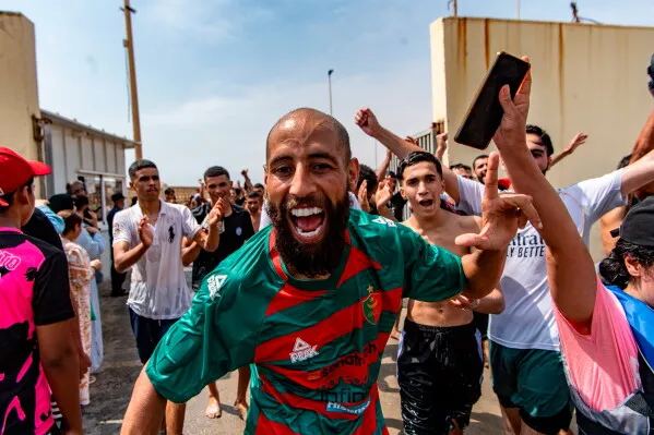 مهاجرون شباب يحتفلون بحماس بعد عبورهم الحدود إلى سبتة، الجيب الإسباني في شمال أفريقيا، وسط موجة هجرة كبيرة من المغرب.
