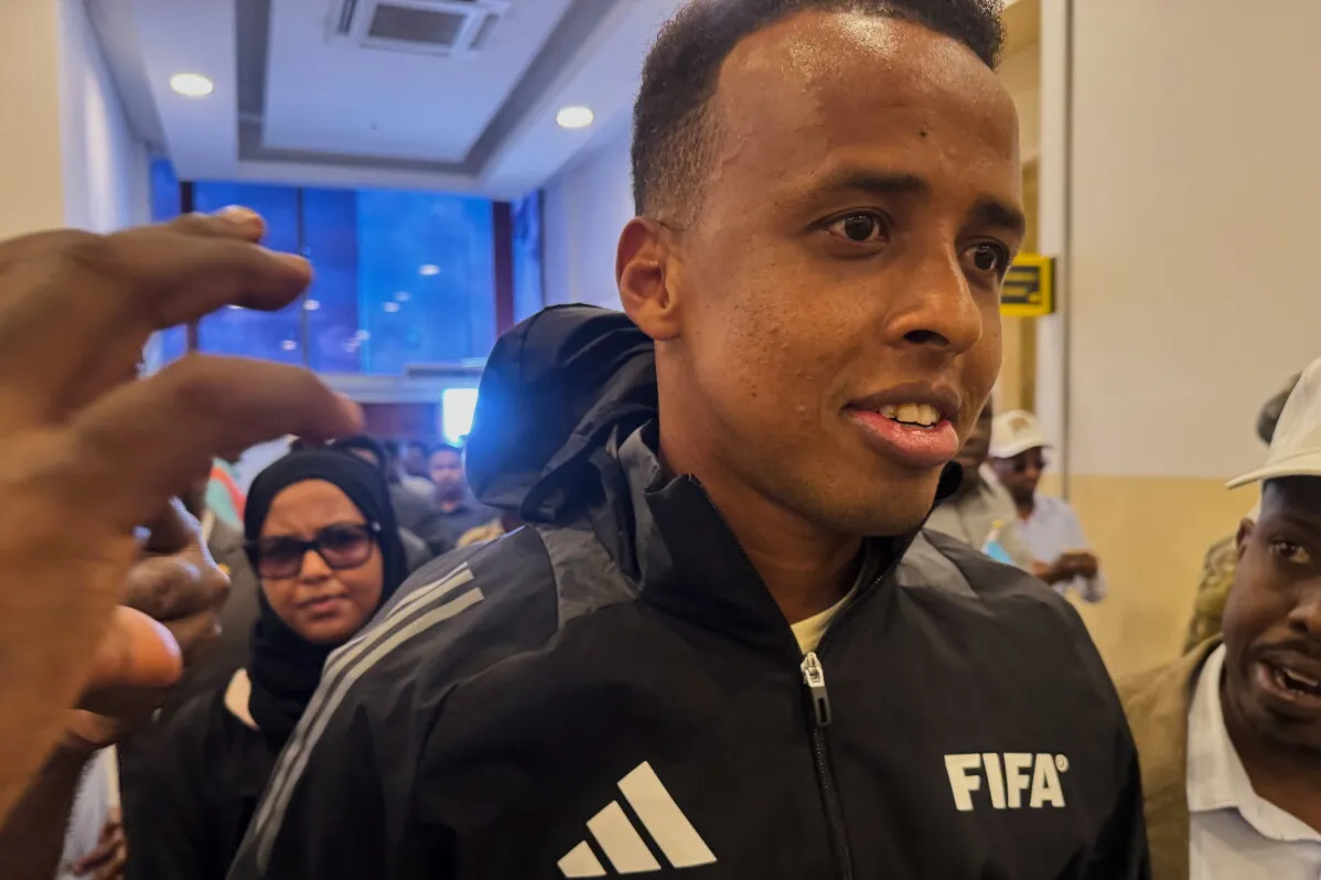 عمر أرتان، الحكم الصومالي، يتلقى استقبالاً حاراً في مطار مقديشو بعد منعه من دخول الولايات المتحدة، مما يعكس أهمية وصوله إلى قائمة حكام كأس العالم.