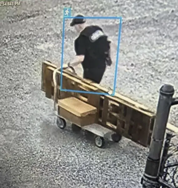 شخص يرتدي زيًا يشبه زي الضباط، يسحب عربة تحتوي على صناديق، يظهر في لقطة من كاميرا المراقبة أثناء هروبه من السجن في أركنساس.