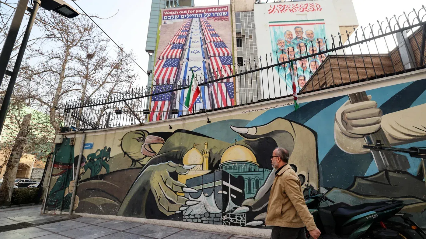 جدارية في طهران تظهر رموزًا وطنية إيرانية وأعلام الولايات المتحدة وإسرائيل، تعكس التوترات السياسية الحالية.