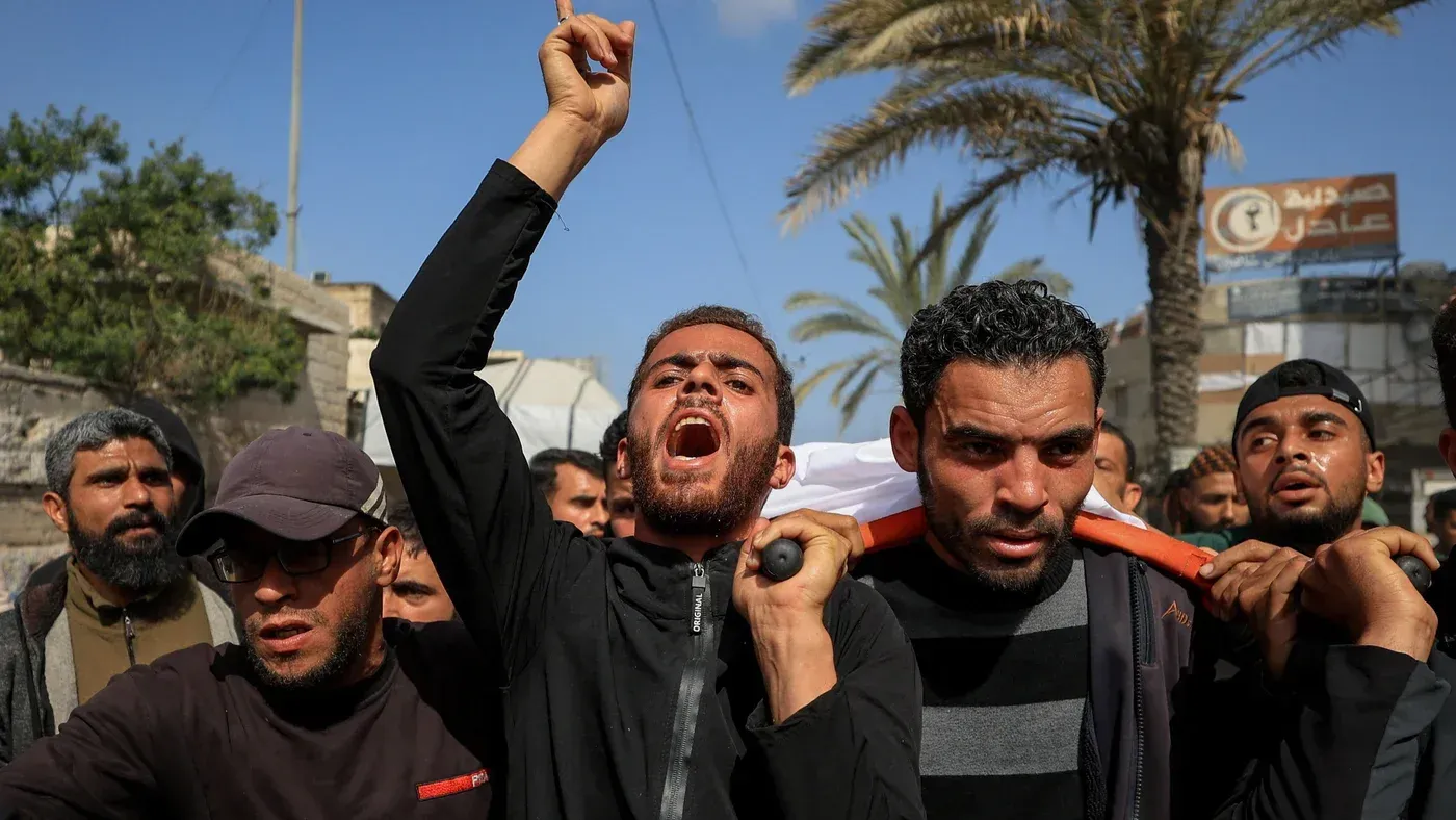 محتجون فلسطينيون يحملون جثمان أحد القتلى، معبرين عن حزنهم وغضبهم في شوارع غزة، وسط أجواء من التوتر بعد الغارات الإسرائيلية.