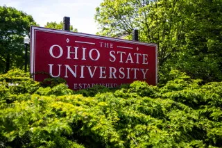لافتة جامعة ولاية أوهايو بين الأشجار، تعبر عن البحث الأكاديمي حول تأثيرات المياه الملحية المشعة المستخدمة على طرق أوهايو.
