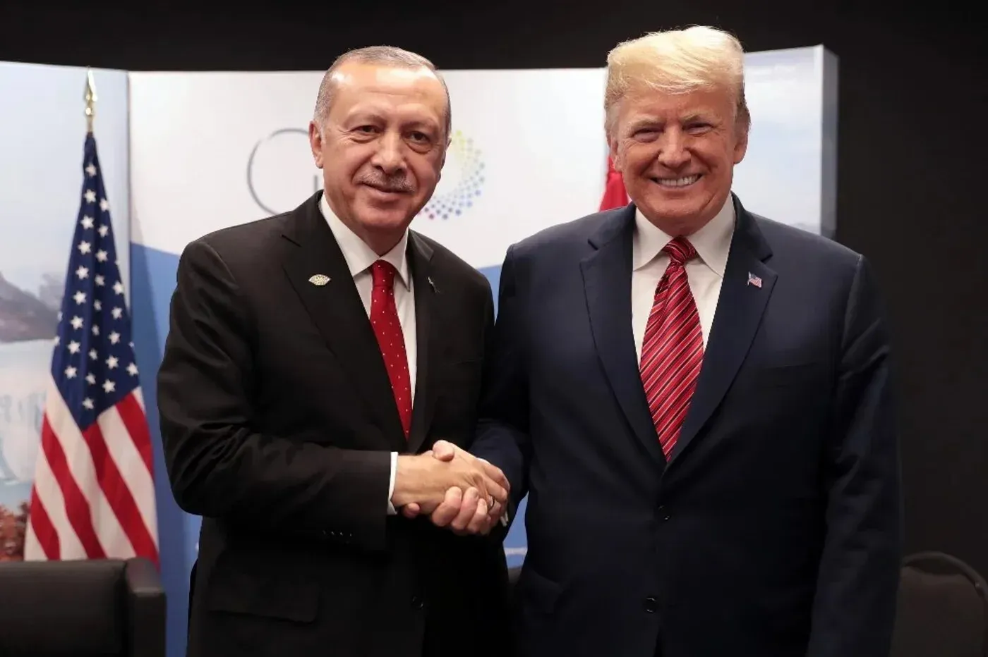 لقاء بين الرئيس التركي رجب طيب أردوغان والرئيس الأمريكي دونالد ترامب، حيث يتصافحان في إطار من التعاون السياسي.