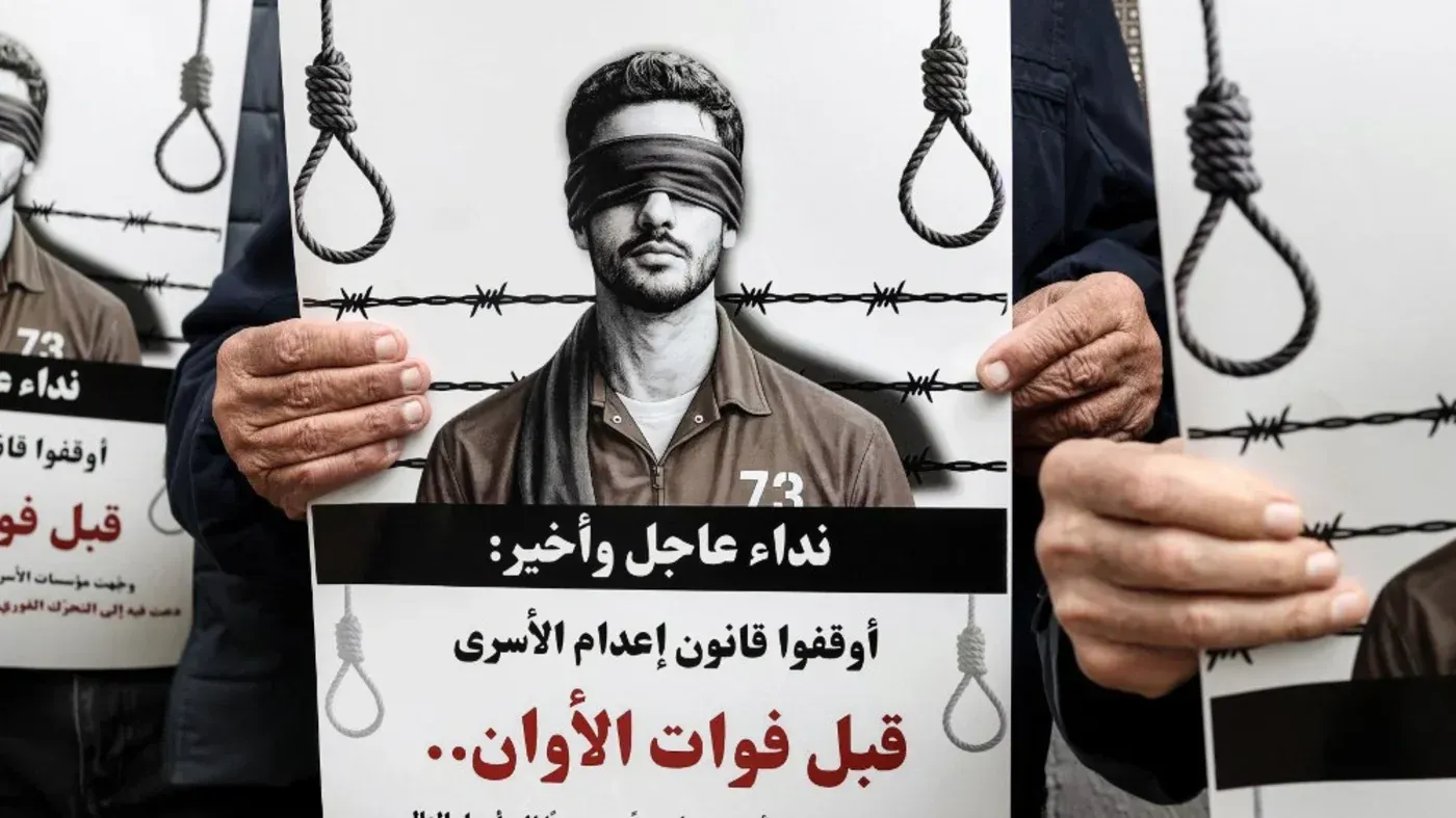 لافتة تحمل صورة شاب معصوب العينين، تدعو لوقف قانون إعدام الأسرى، مع تعبير عن القلق من تداعياته على حقوق الإنسان.