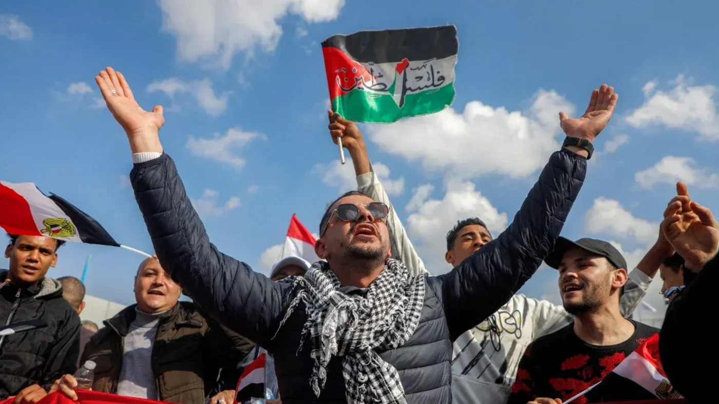 محتجون يرفعون الأعلام الفلسطينية والمصرية خلال تظاهرة، معبرين عن دعمهم للقضية الفلسطينية وسط أجواء من الحماس.