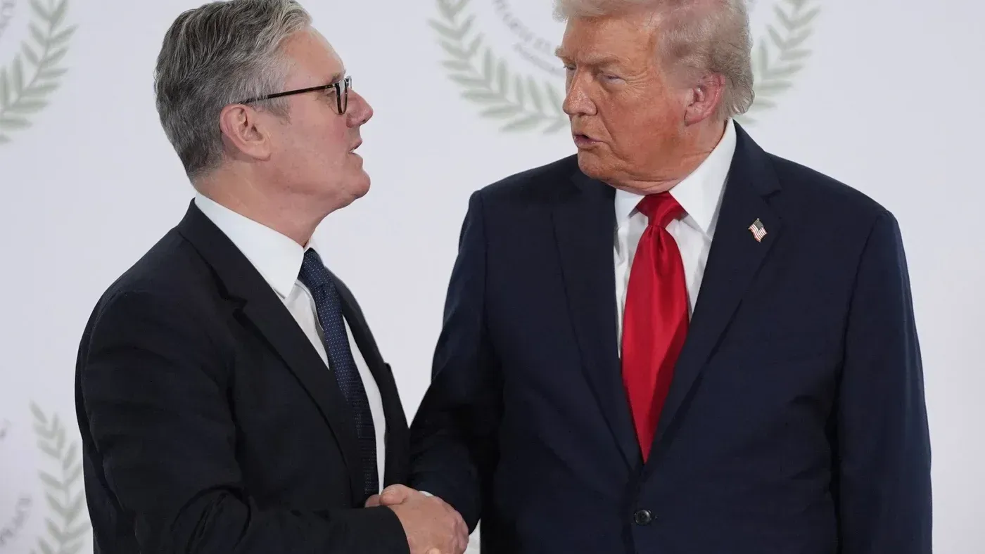 لقاء بين كير ستارمر ودونالد ترامب، حيث يتبادلان التحية، مع خلفية بسيطة تبرز أهمية العلاقات السياسية في سياق الأزمات العالمية.