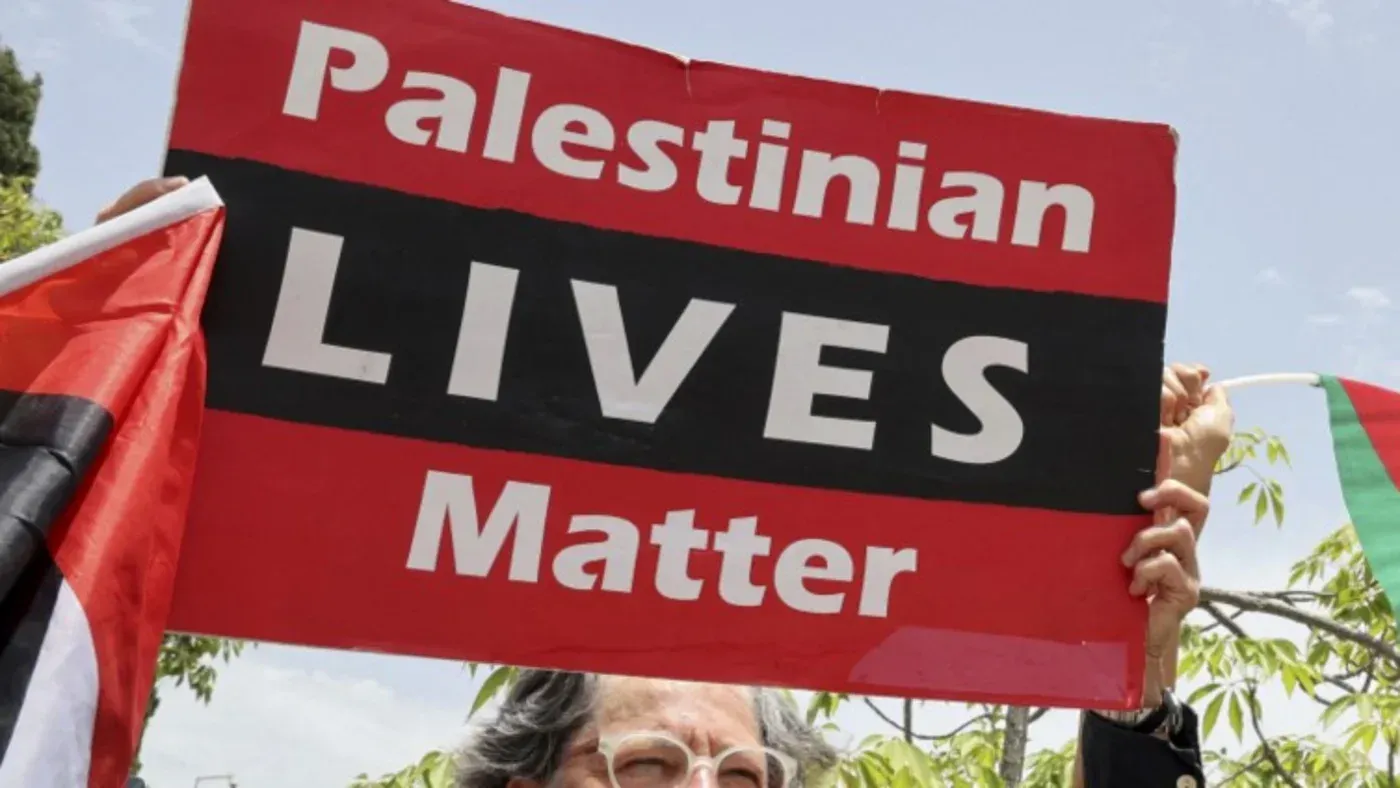 لافتة تحمل عبارة "حياة الفلسطينيين مهمة" خلال مظاهرة، تعكس دعم الفلسطينيين في مواجهة القمع والتمييز.