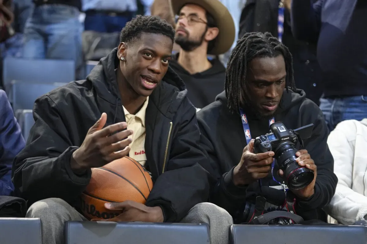 شاب يُظهر مهاراته في كرة السلة أثناء حضوره مباراة NBA في باريس، مع وجود كرة سلة وكاميرا.