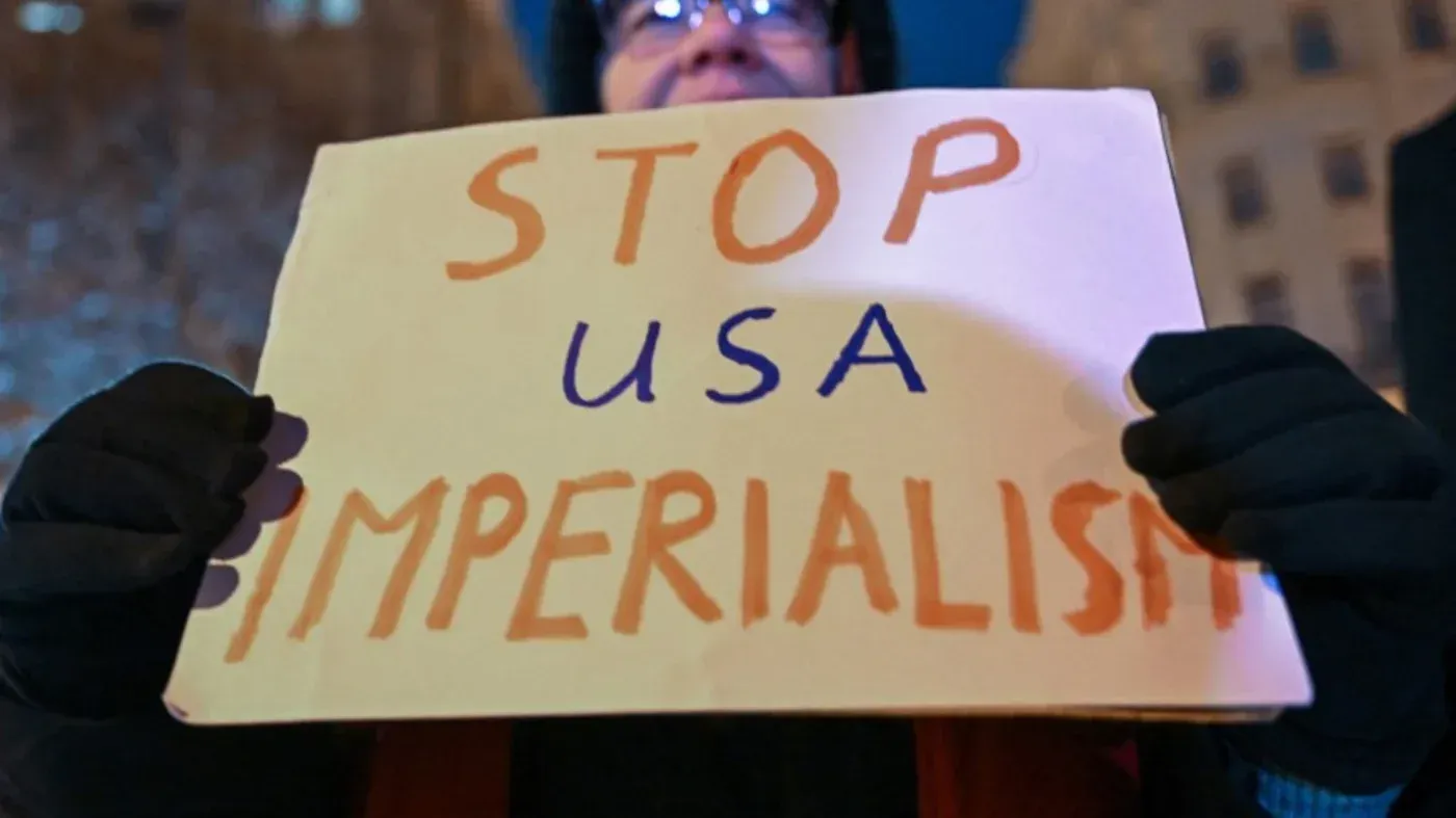 لافتة تحمل عبارة "أوقفوا الإمبريالية الأمريكية" خلال احتجاج، تعبر عن معارضة التدخل الأمريكي في الشؤون الدولية.
