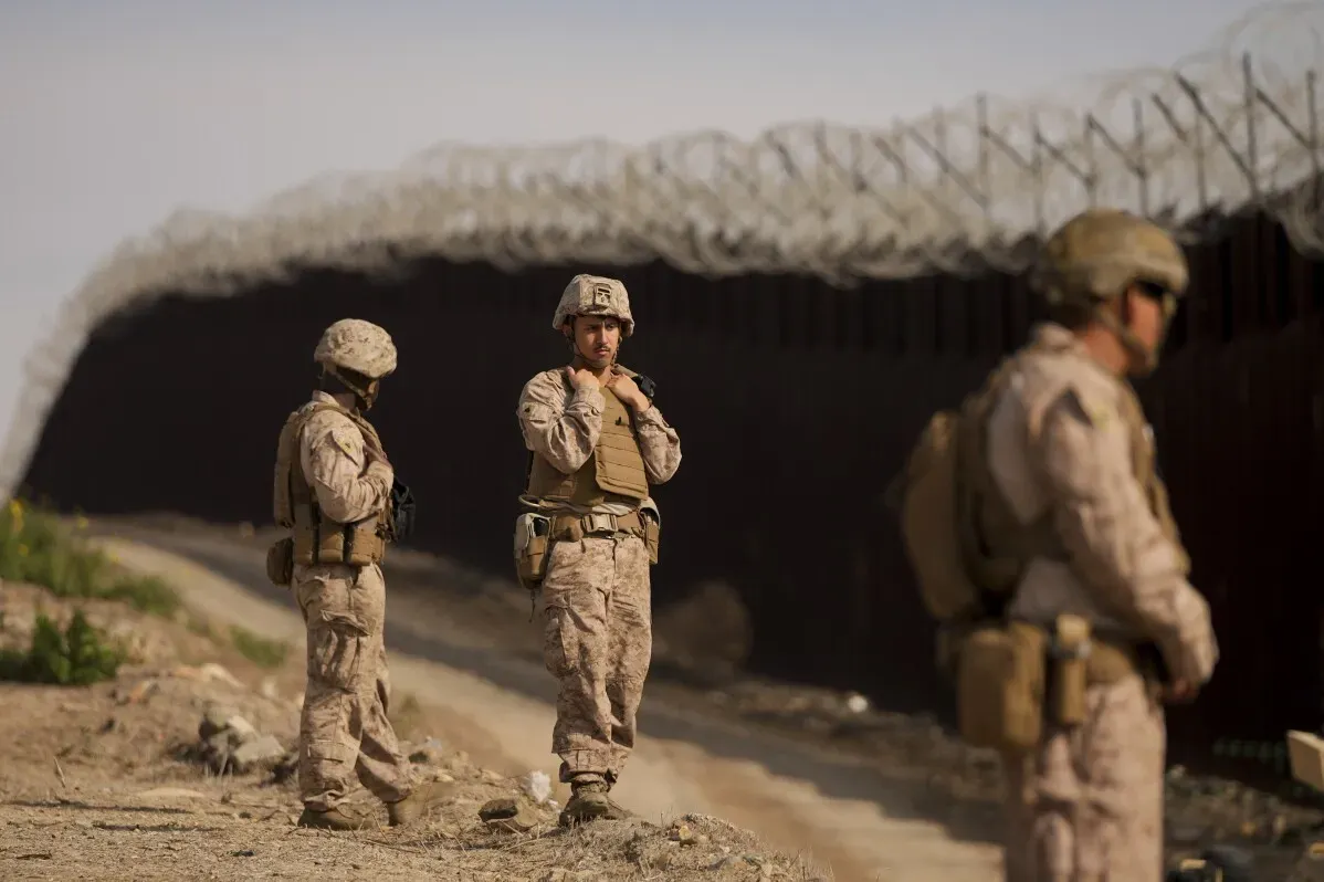 عناصر من مشاة البحرية الأمريكية ينشرون أسلاك شائكة على الحدود بين سان دييغو وتيخوانا، لتعزيز الحواجز ضد الهجرة غير الشرعية.