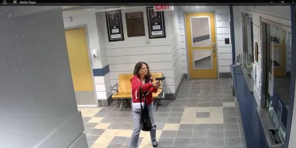 امرأة تحمل مسدسًا في بهو قسم الشرطة، حيث أطلقت عدة طلقات. الحادث وقع في كونيتيكت، مما أدى إلى اعتقالها بعد ذلك.