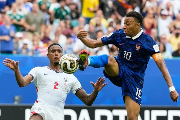 لاعب فرنسي يرتدي الرقم 10 يسيطر على الكرة في مواجهة لاعب إنجليزي خلال مباراة في كأس العالم 2025 بأمريكا الشمالية.