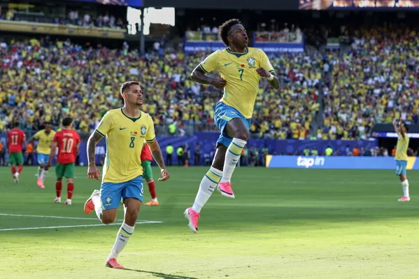 لاعبو منتخب البرازيل يحتفلون بهدف في مباراة ضد المغرب، مع جمهور كبير في الخلفية، خلال كأس العالم في الولايات المتحدة.