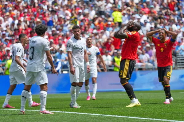 لاعبو بلجيكا يتفاعلون بعد فرصة ضائعة خلال مباراة كأس العالم ضد مصر، مع وجود مشجعين في المدرجات.