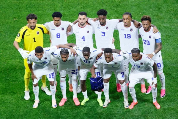 فريق الرأس الأخضر يتجمع قبل المباراة، مرتديًا زيّه الأبيض، في كأس العالم، مع التركيز على الروح الجماعية والتحديات المقبلة.