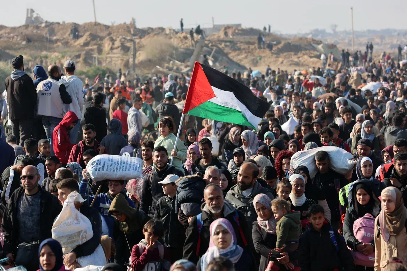 تجمع حشود من الفلسطينيين في غزة حاملي علم فلسطين، وسط أجواء من التوتر والاحتجاج على خطط تهجيرهم المقترحة.