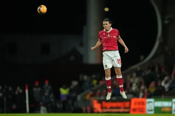 لاعب كرة قدم يرتدي زي فريق نوتنجهام فورست يقفز عالياً أثناء المباراة، مع خلفية جماهيرية مضاءة، في لحظة حماسية من كأس الاتحاد الإنجليزي.