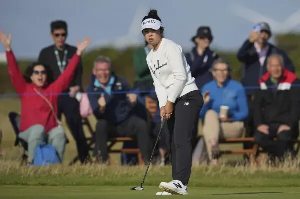 ميو ياماشيتا تسدد الكرة في بطولة بريطانيا المفتوحة للسيدات، مع تفاعل الجمهور خلفها، وسط أجواء تنافسية قوية.