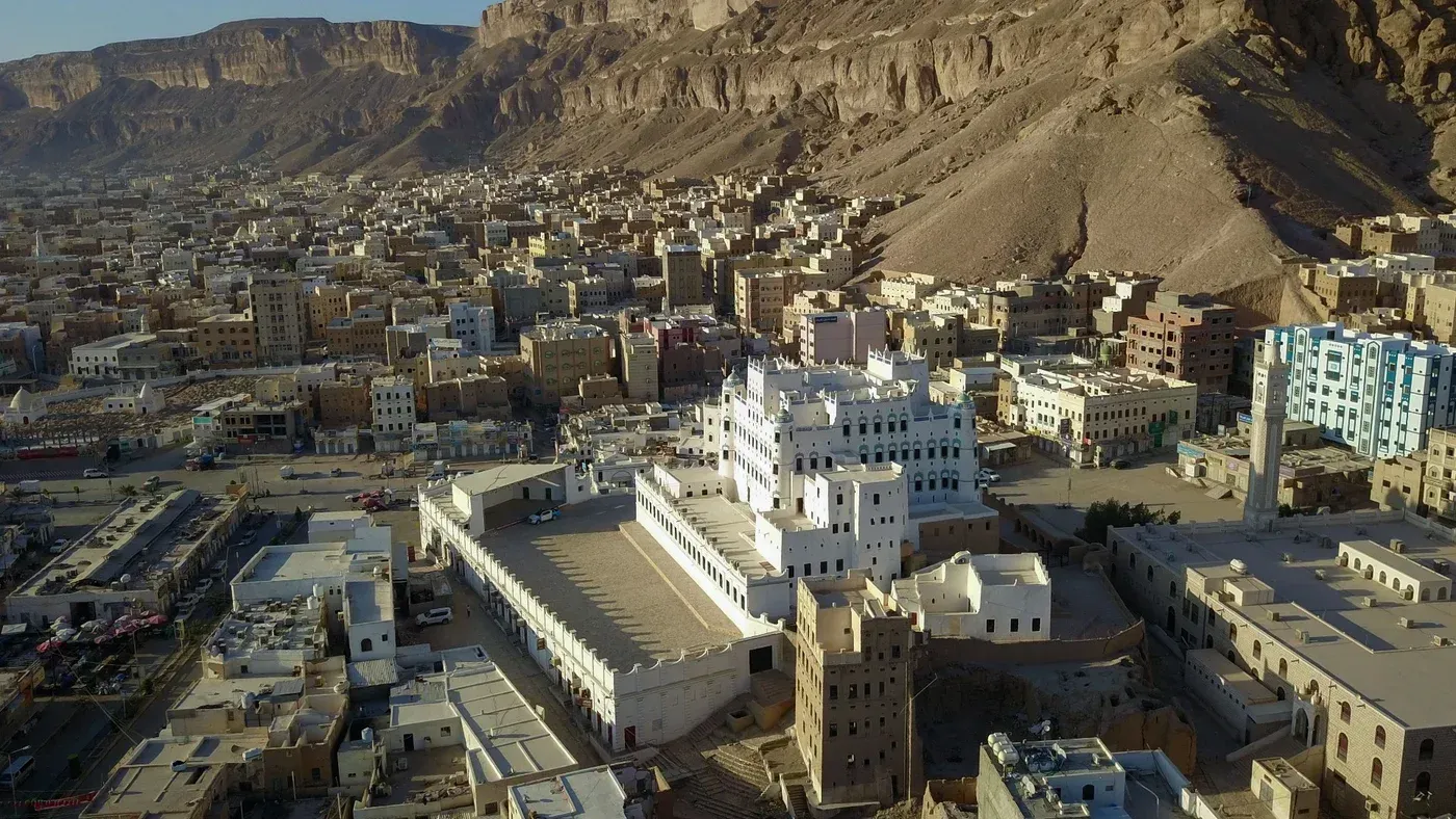 صورة جوية لمدينة سيئون، تظهر المباني التقليدية والحديثة محاطة بالجبال، تعكس أهمية المدينة الاستراتيجية في حضرموت.