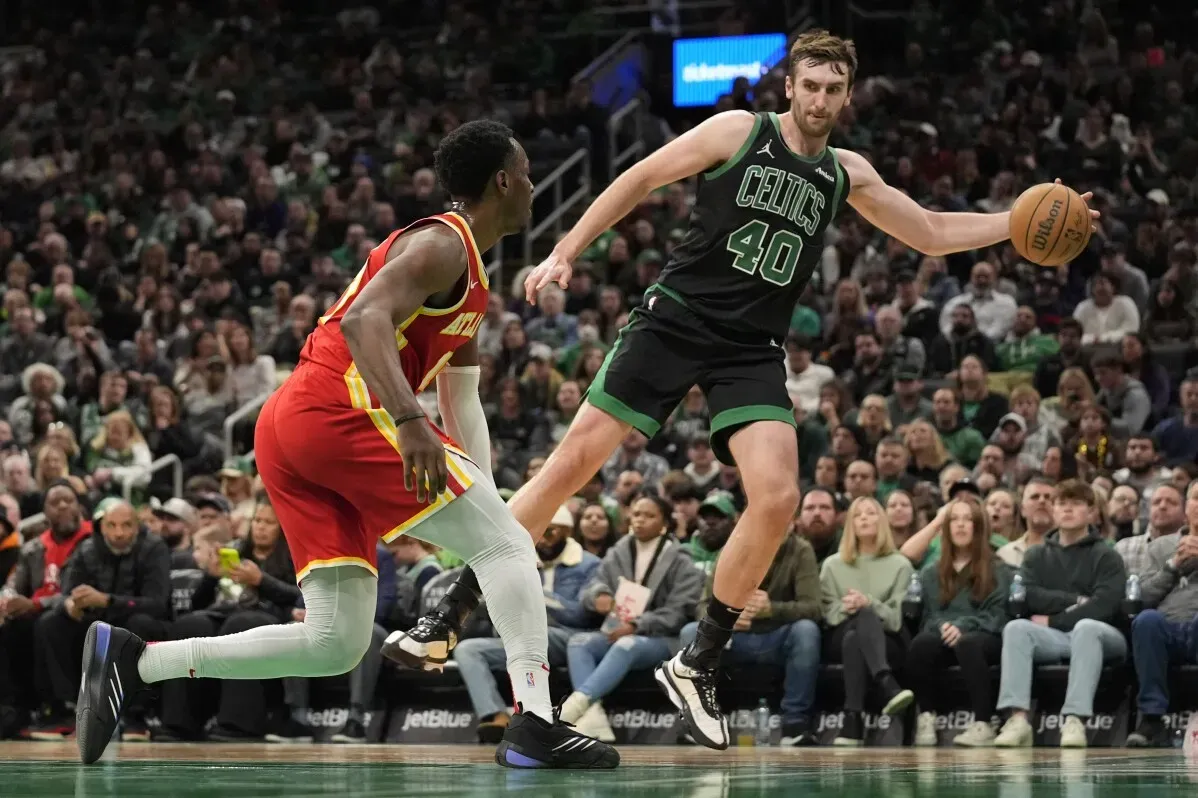 لاعب كرة سلة من فريق بوسطن سيلتيكس يت dribble كرة سلة خلال مباراة مثيرة ضد أتلانتا هوكس في أجواء حماسية.