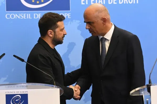 الرئيس الأوكراني فولوديمير زيلينسكي يصافح مسؤولًا في مجلس أوروبا خلال إعلانه عن إنشاء محكمة دولية لمحاكمة المسؤولين الروس عن الغزو.