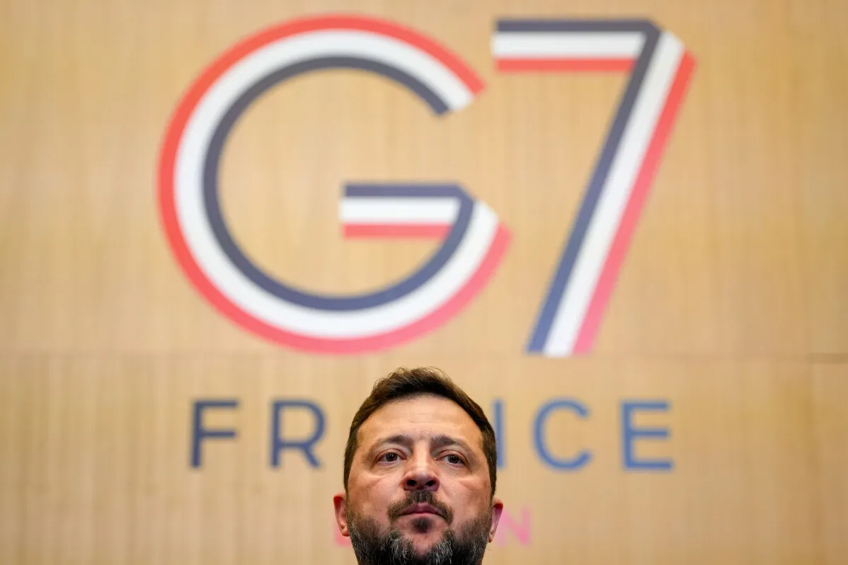 زيلينسكي يتحدث في قمة مجموعة السبع في فرنسا، مع شعار القمة خلفه، حيث يركز على تعزيز الدعم لأوكرانيا في مواجهة روسيا.
